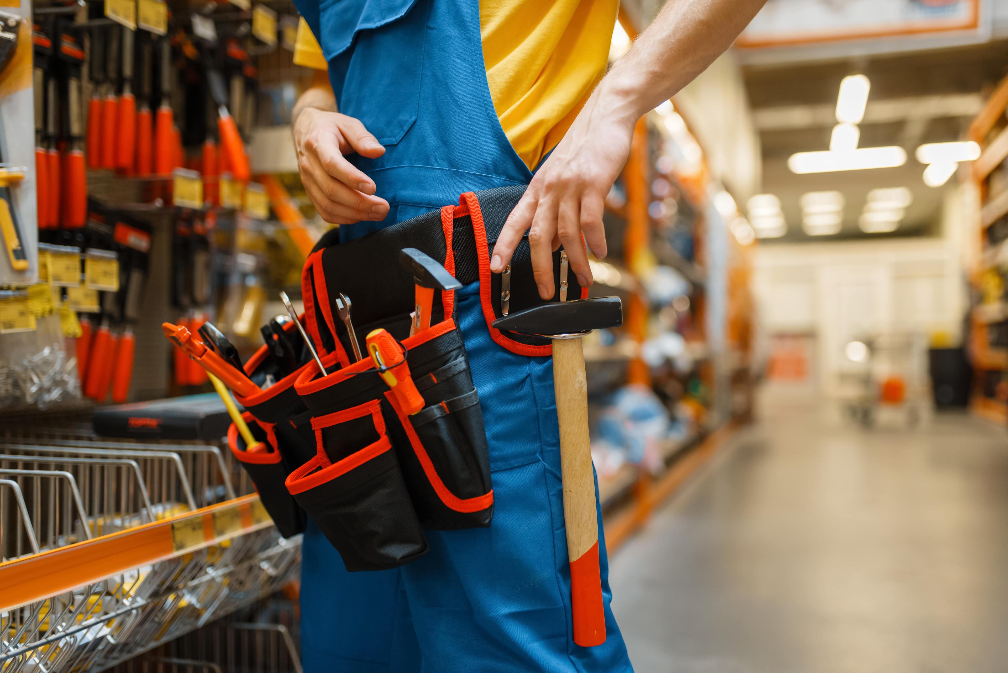 male-builder-trying-on-tool-belt-in-hardware-store-2021-08-26-16-26-08-utc-min.jpg